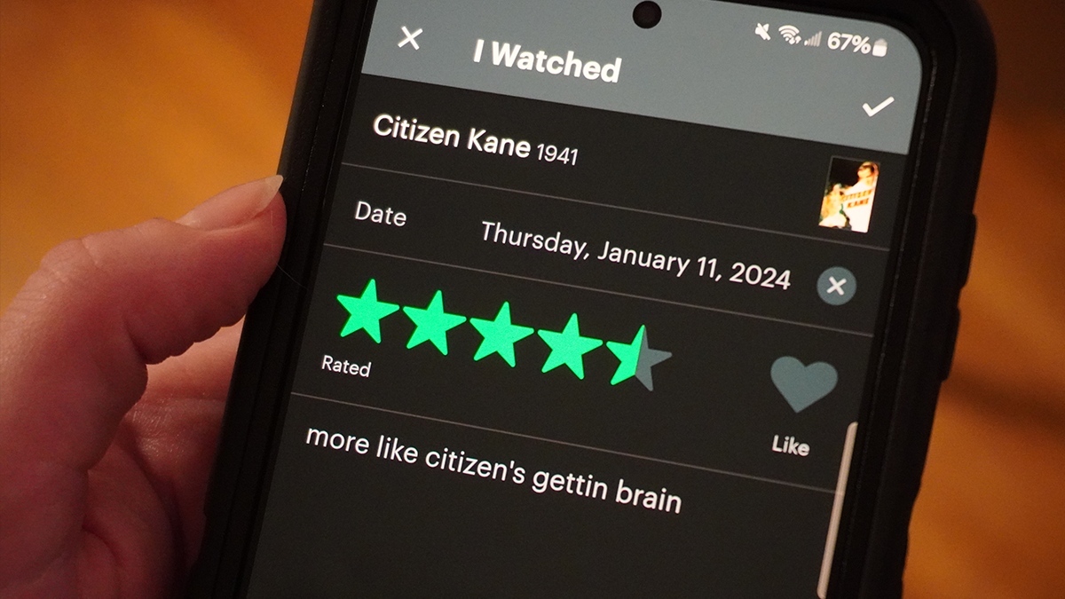 A photo of a phone with a review for Citizen Kane; it gives 4.5 stars and says "more like citizen's gettin brain"